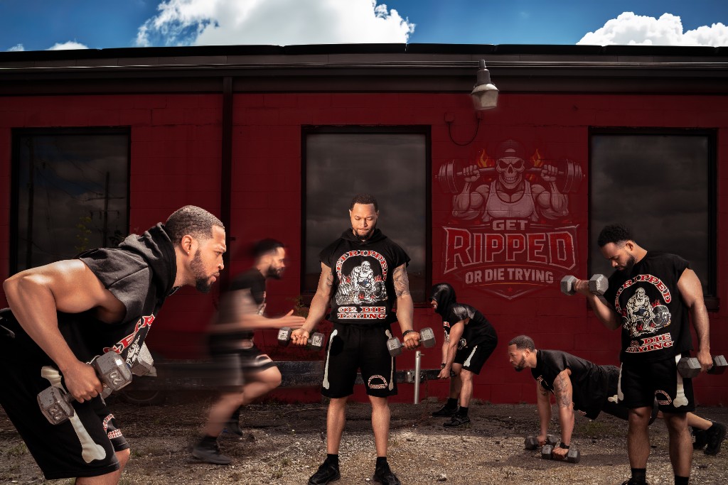 The GRODT crew training outside a red brick building in Detroit, lifting dumbbells and doing pushups